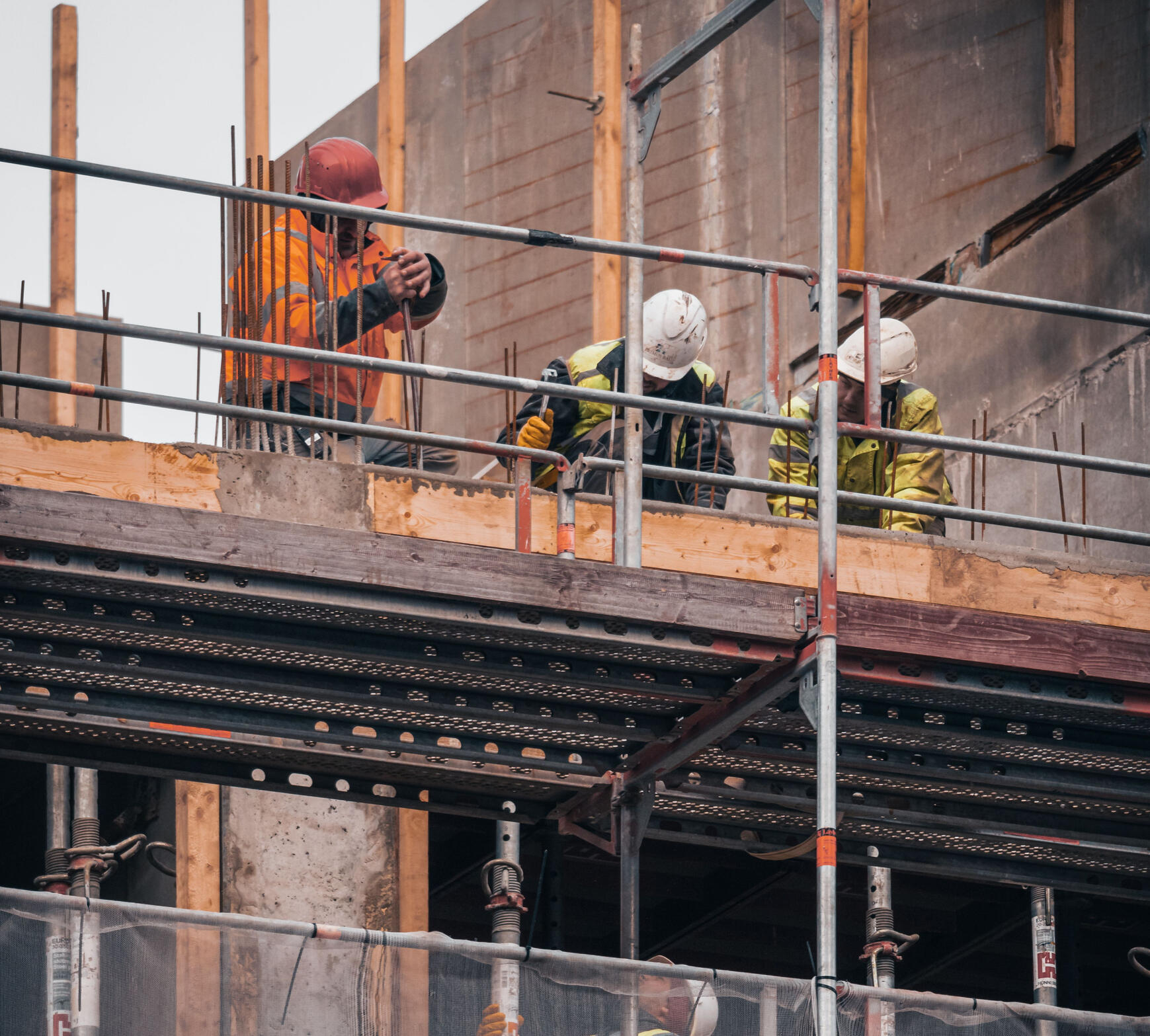 Trabajadores en andamios de obra en construcción